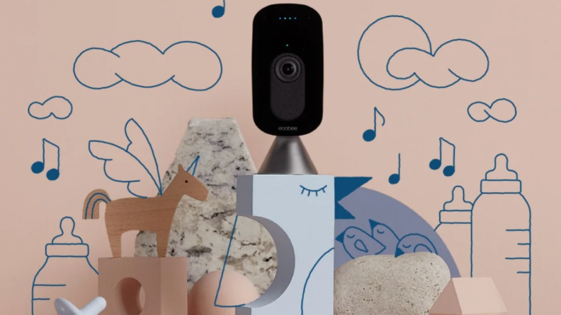Ecobee SmartCamera surrounded by multi-colored building blocks, a blue pacifier and drawings of music notes, baby bottles, stars and the moon.